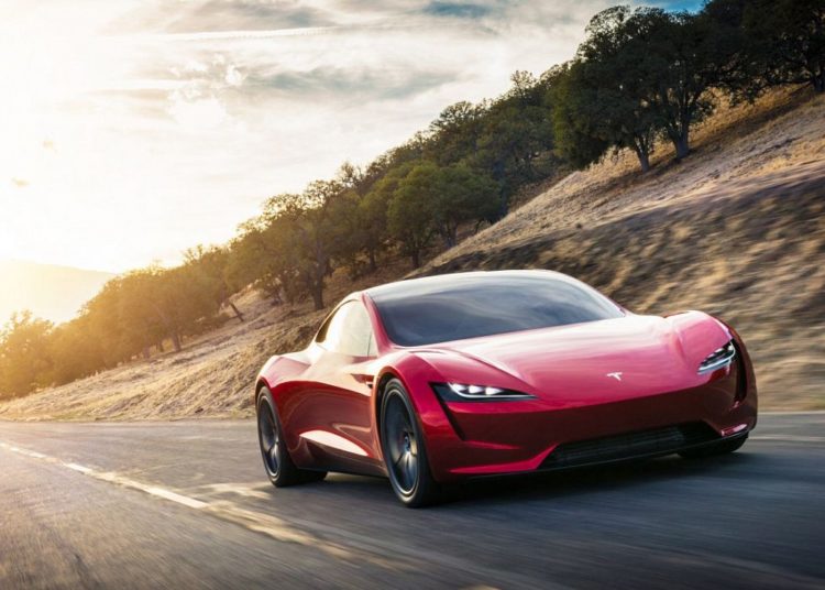 Красный родстер Tesla на дороге
